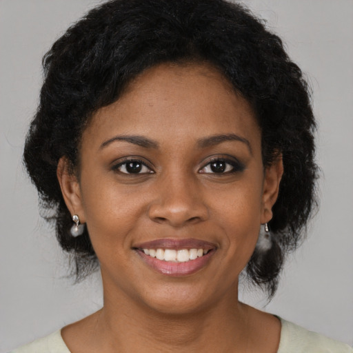 Joyful black young-adult female with medium  brown hair and brown eyes