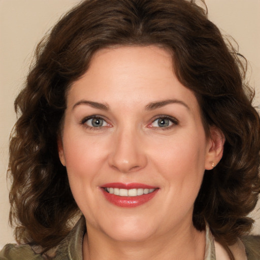 Joyful white adult female with medium  brown hair and brown eyes