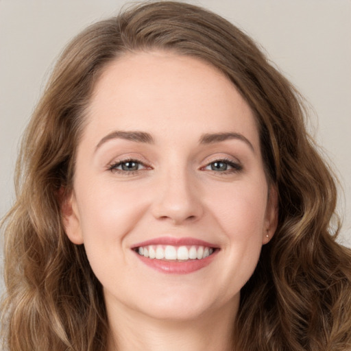 Joyful white young-adult female with long  brown hair and green eyes