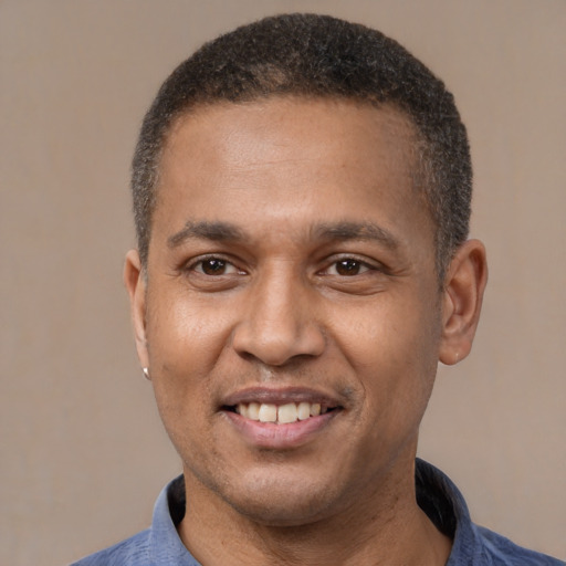 Joyful latino adult male with short  black hair and brown eyes