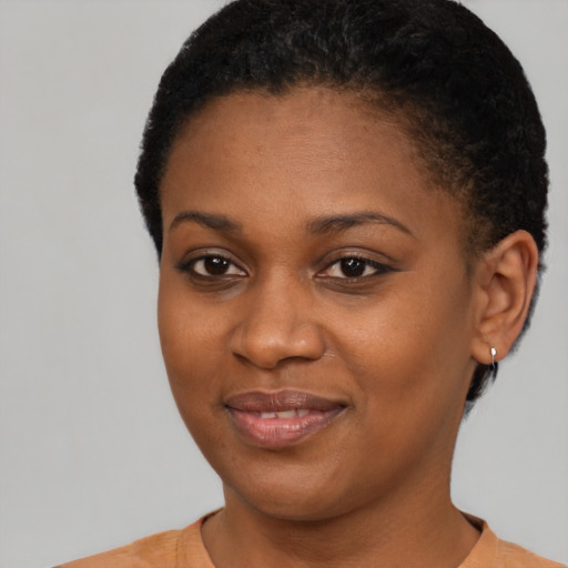 Joyful black young-adult female with short  brown hair and brown eyes