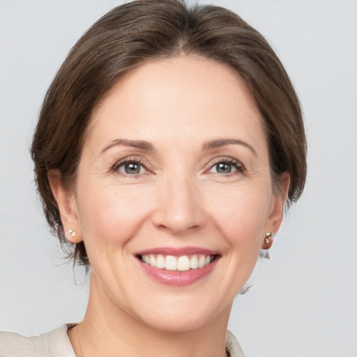 Joyful white adult female with medium  brown hair and grey eyes