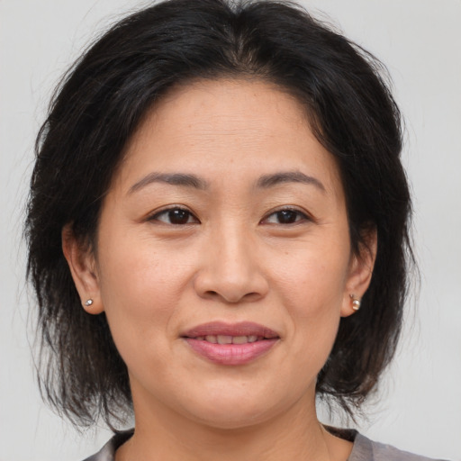 Joyful asian adult female with medium  brown hair and brown eyes