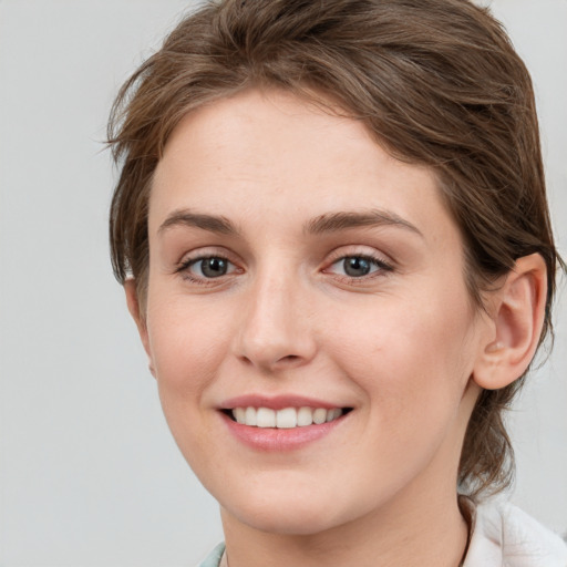 Joyful white young-adult female with medium  brown hair and grey eyes