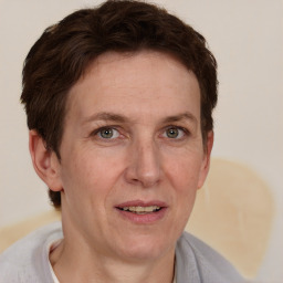 Joyful white adult female with short  brown hair and blue eyes