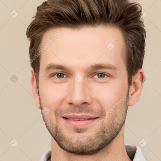 Joyful white young-adult male with short  brown hair and grey eyes