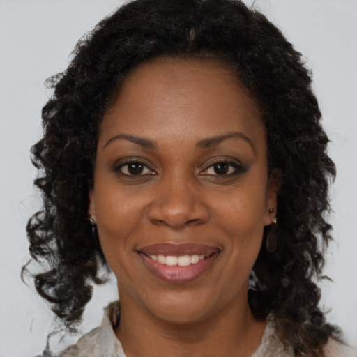 Joyful black adult female with medium  brown hair and brown eyes