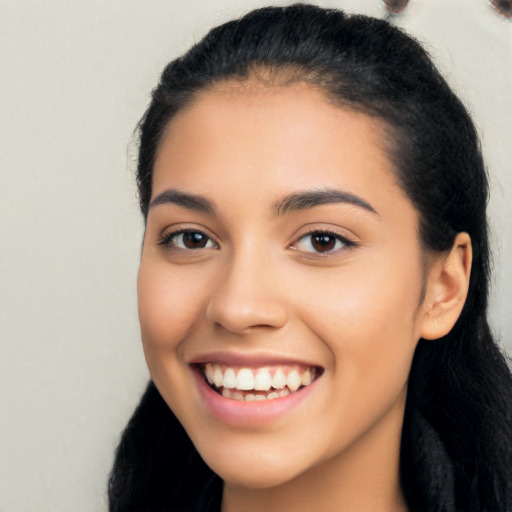 Joyful latino young-adult female with long  black hair and brown eyes