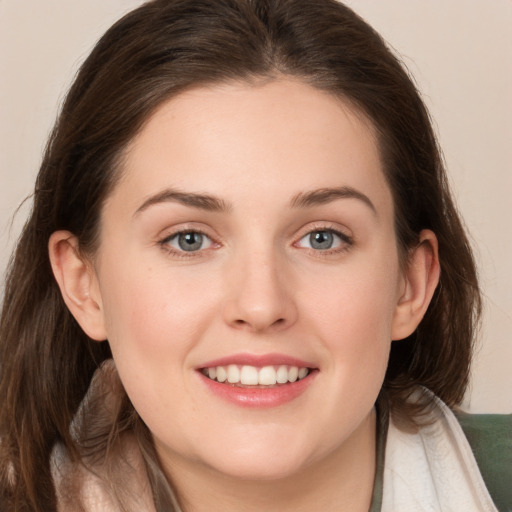 Joyful white young-adult female with medium  brown hair and green eyes