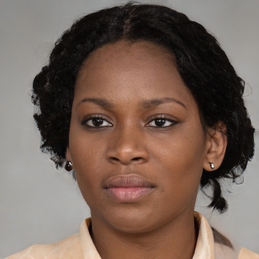 Joyful black young-adult female with medium  black hair and brown eyes