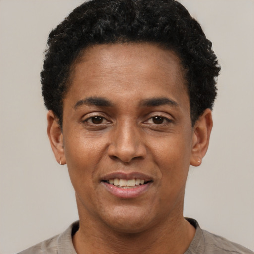 Joyful black adult male with short  black hair and brown eyes