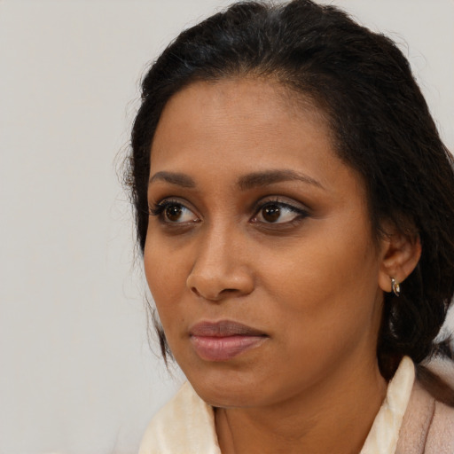 Joyful black adult female with medium  brown hair and brown eyes