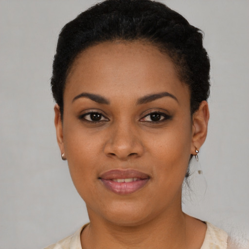 Joyful black young-adult female with short  black hair and brown eyes
