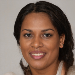 Joyful black adult female with medium  brown hair and brown eyes