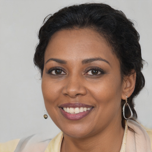 Joyful black young-adult female with long  brown hair and brown eyes