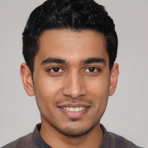 Joyful latino young-adult male with short  black hair and brown eyes