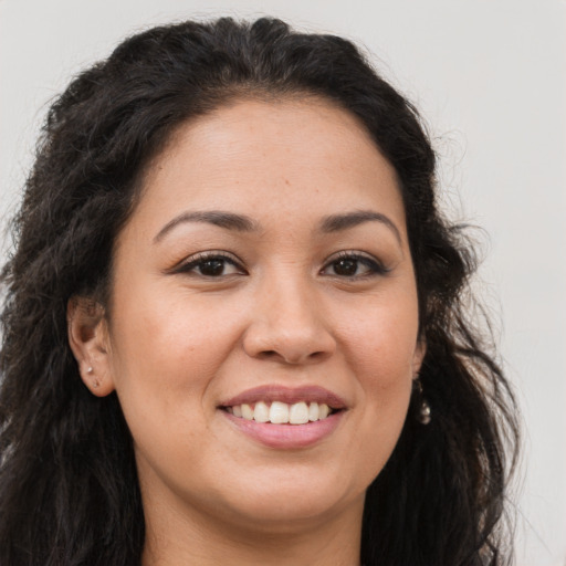 Joyful latino young-adult female with long  brown hair and brown eyes