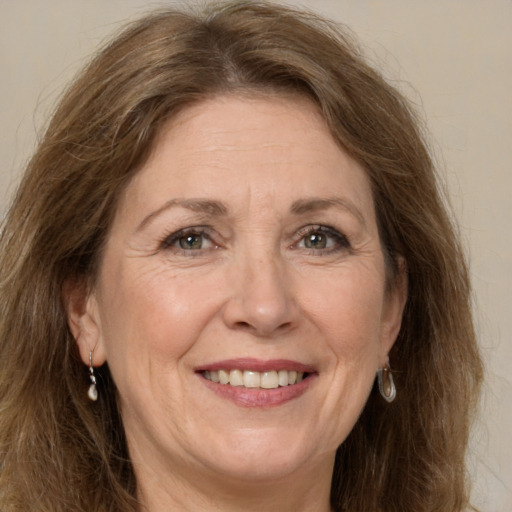 Joyful white adult female with long  brown hair and grey eyes