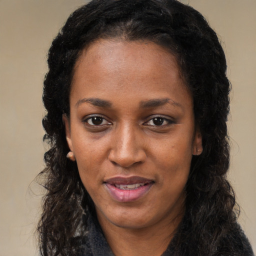 Joyful black young-adult female with long  black hair and brown eyes