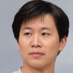 Joyful asian adult male with short  brown hair and brown eyes