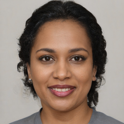 Joyful black young-adult female with medium  brown hair and brown eyes