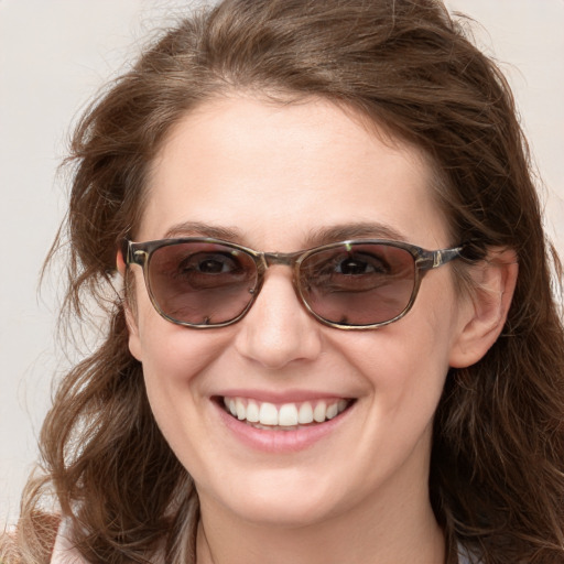 Joyful white young-adult female with long  brown hair and blue eyes