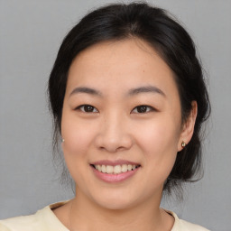 Joyful asian young-adult female with medium  brown hair and brown eyes