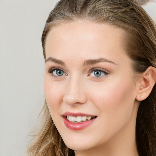 Joyful white young-adult female with long  brown hair and blue eyes