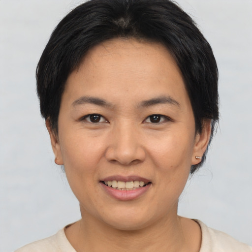 Joyful asian young-adult female with short  black hair and brown eyes