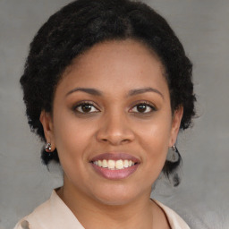 Joyful black young-adult female with long  brown hair and brown eyes