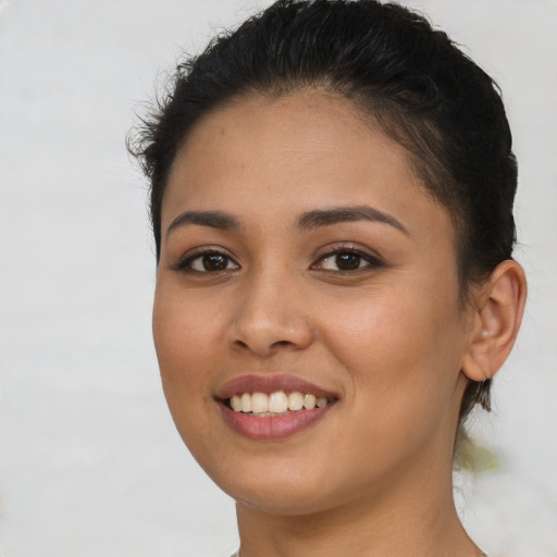 Joyful latino young-adult female with short  brown hair and brown eyes