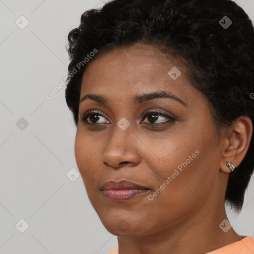 Joyful black young-adult female with short  black hair and brown eyes