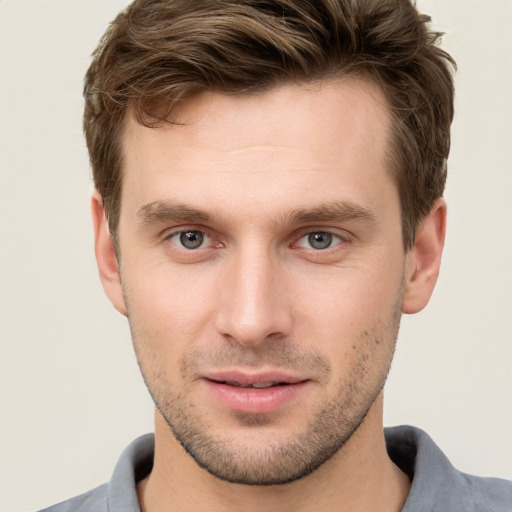 Joyful white young-adult male with short  brown hair and grey eyes