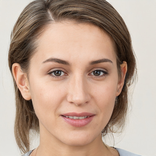 Joyful white young-adult female with medium  brown hair and grey eyes