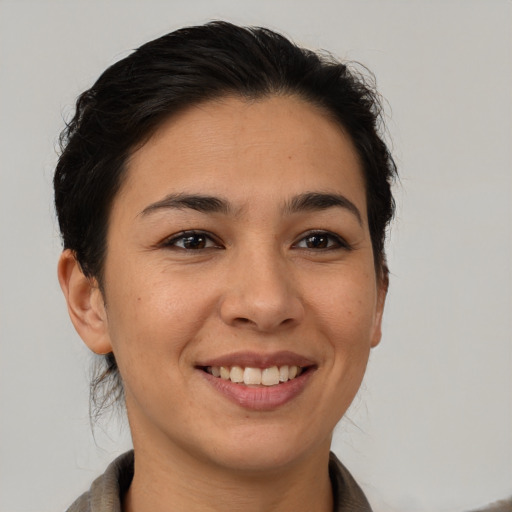Joyful latino young-adult female with short  brown hair and brown eyes