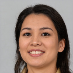 Joyful latino young-adult female with long  brown hair and brown eyes