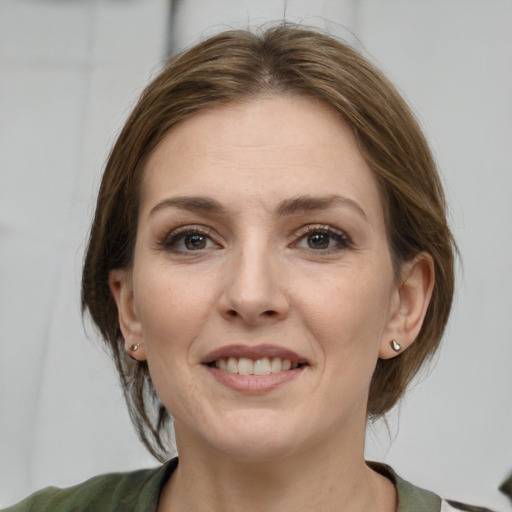 Joyful white young-adult female with medium  brown hair and grey eyes