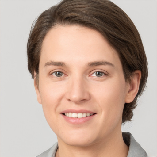 Joyful white young-adult female with medium  brown hair and grey eyes