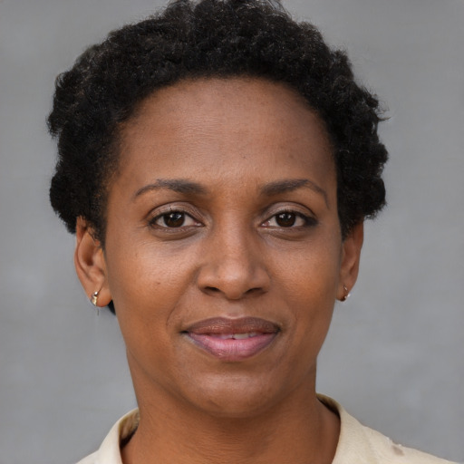 Joyful black adult female with short  brown hair and brown eyes