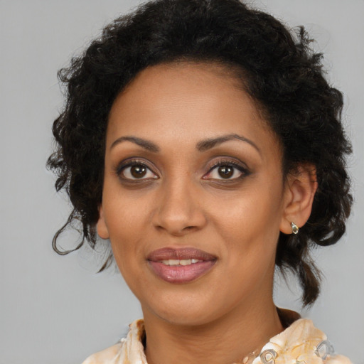 Joyful black adult female with medium  brown hair and brown eyes