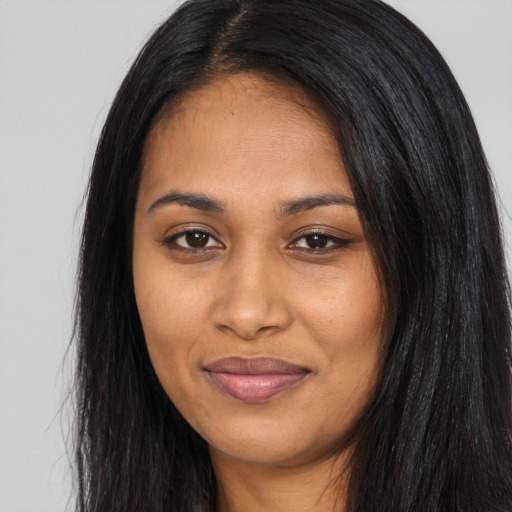 Joyful black young-adult female with long  black hair and brown eyes