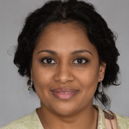 Joyful black adult female with medium  brown hair and brown eyes