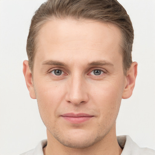 Joyful white young-adult male with short  brown hair and grey eyes