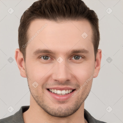 Joyful white young-adult male with short  brown hair and grey eyes