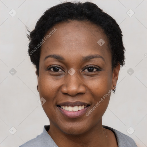 Joyful black young-adult female with short  black hair and brown eyes