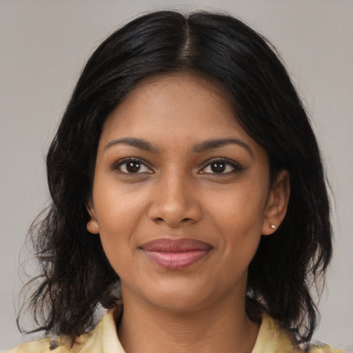 Joyful black young-adult female with medium  brown hair and brown eyes