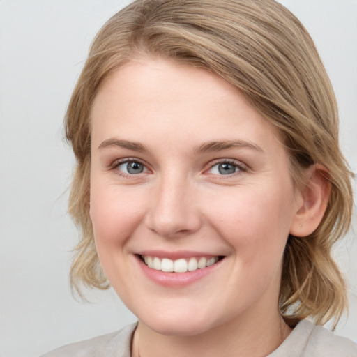 Joyful white young-adult female with medium  brown hair and blue eyes