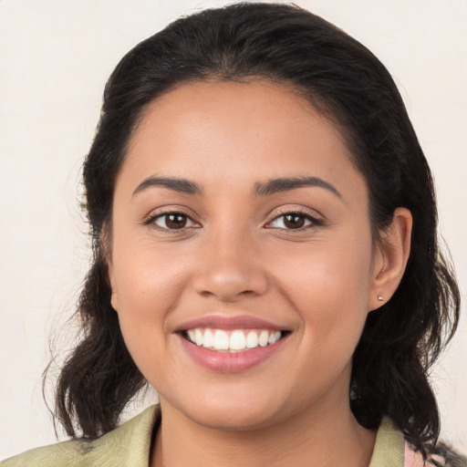 Joyful latino young-adult female with medium  brown hair and brown eyes