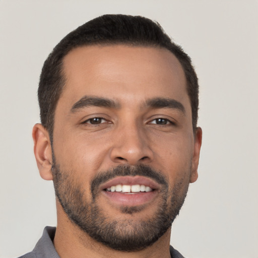 Joyful latino young-adult male with short  black hair and brown eyes