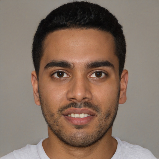 Joyful black young-adult male with short  black hair and brown eyes